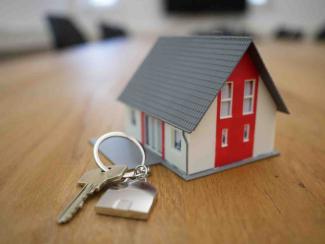 Set of keys beside miniature house